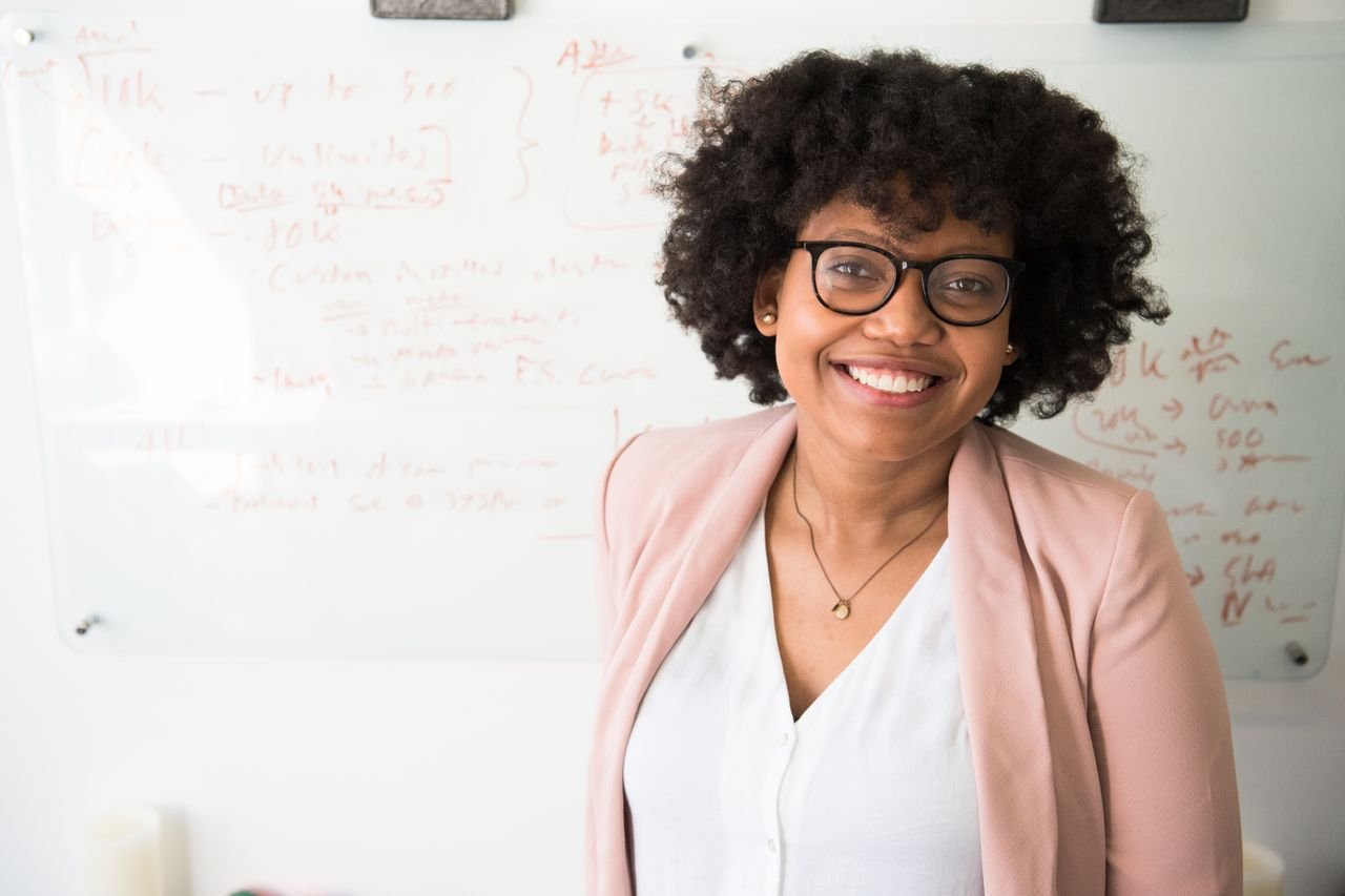 Smiling marketer standing in front of a whiteboard with campaign notes